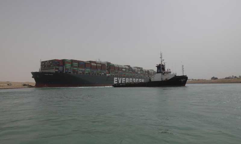 a-man-waves-an-egyptian-flag-as-ship-ever-given-one-of-the-world-s-largest-container-ships-is-seen-after-it-was-fully-floated-in-suez-canal-rapidnews-dailyrapid