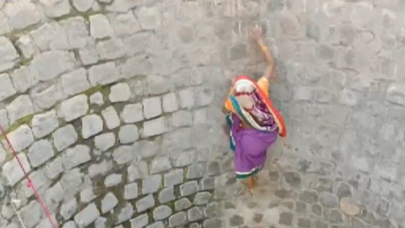 A woman in India endangering her life for water.